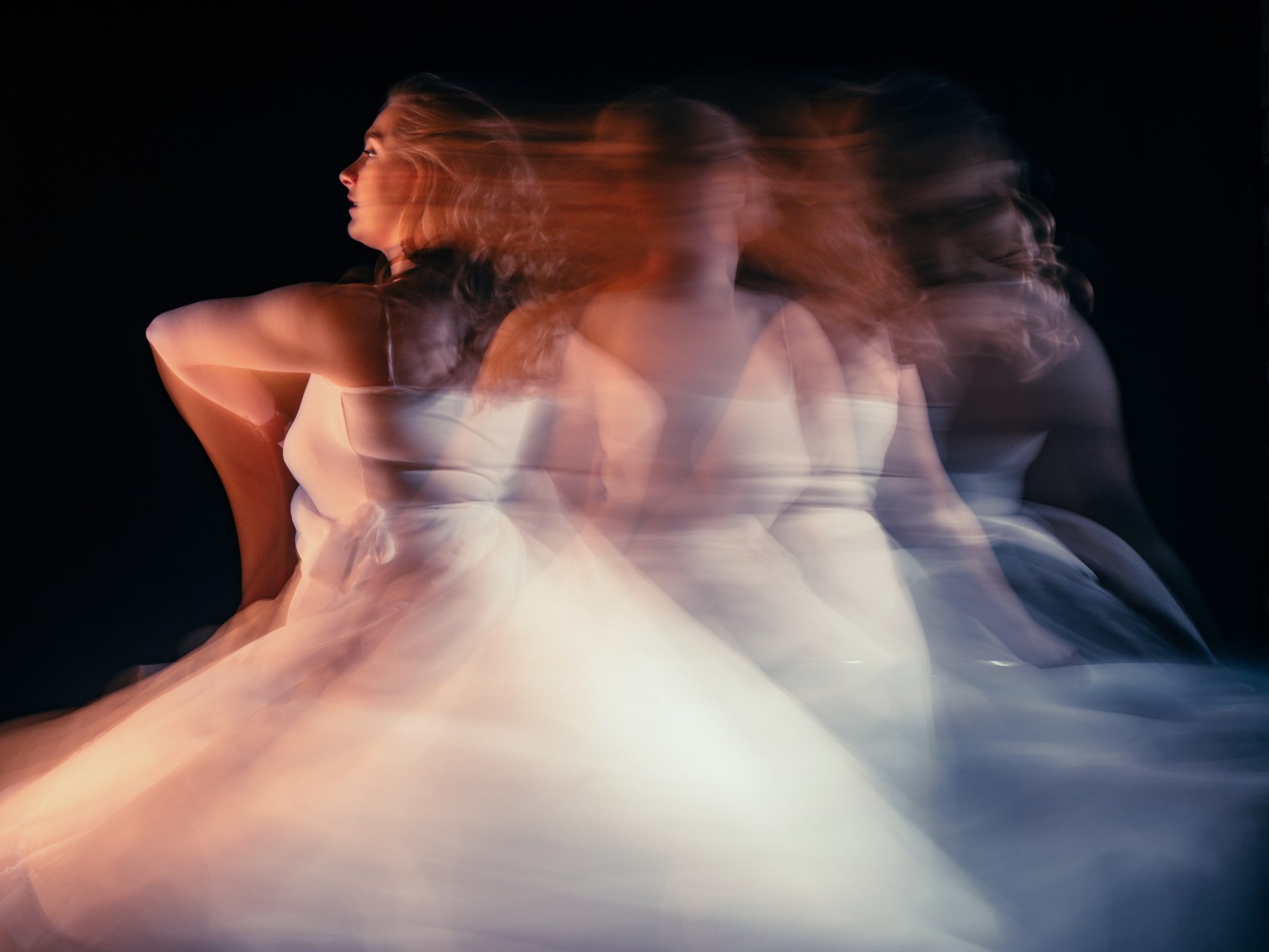 Hingebungsvolle Tänzerin im Rampenlicht, umgeben von Schwärze
